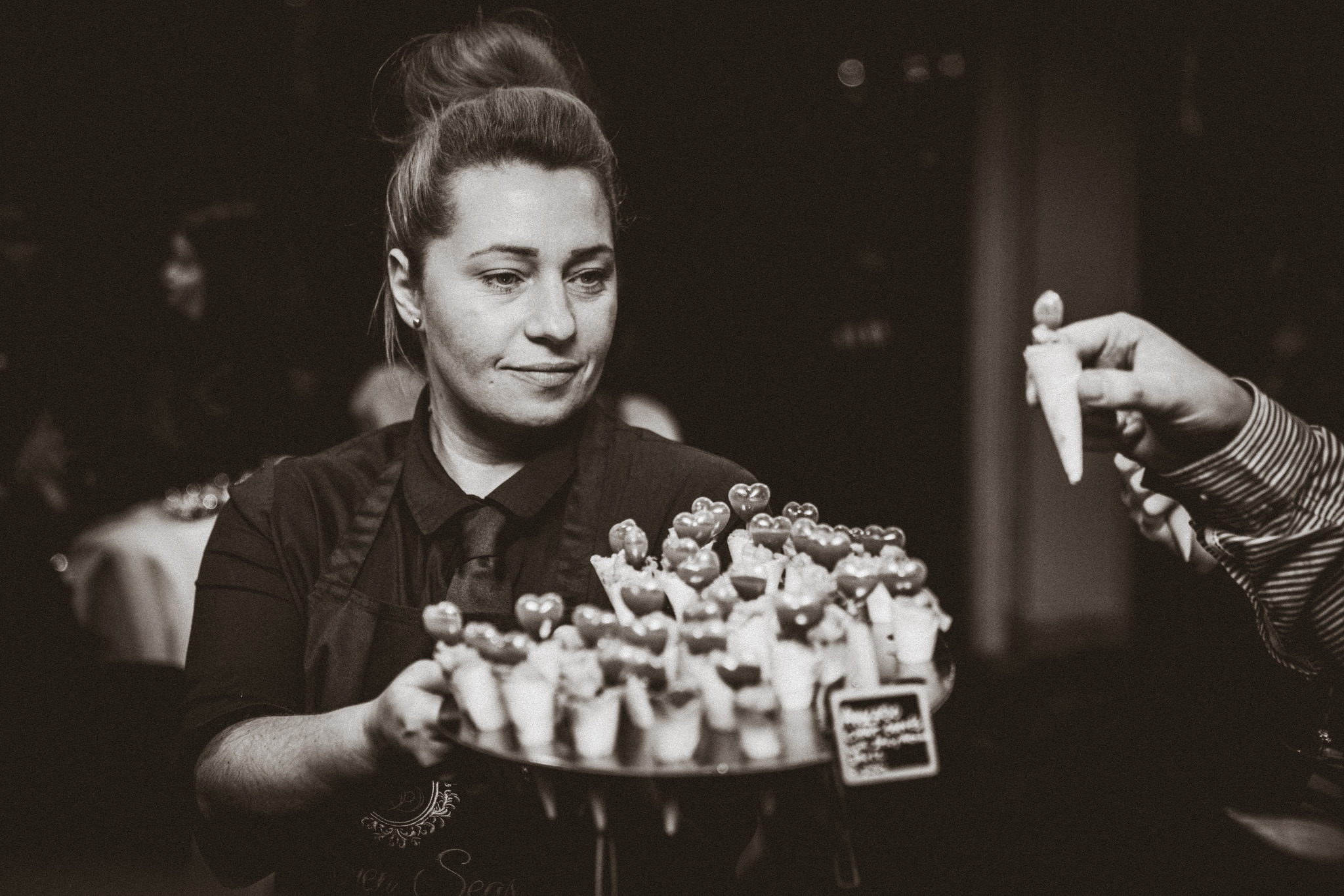 A Seven Seas team member serving canapés at an event